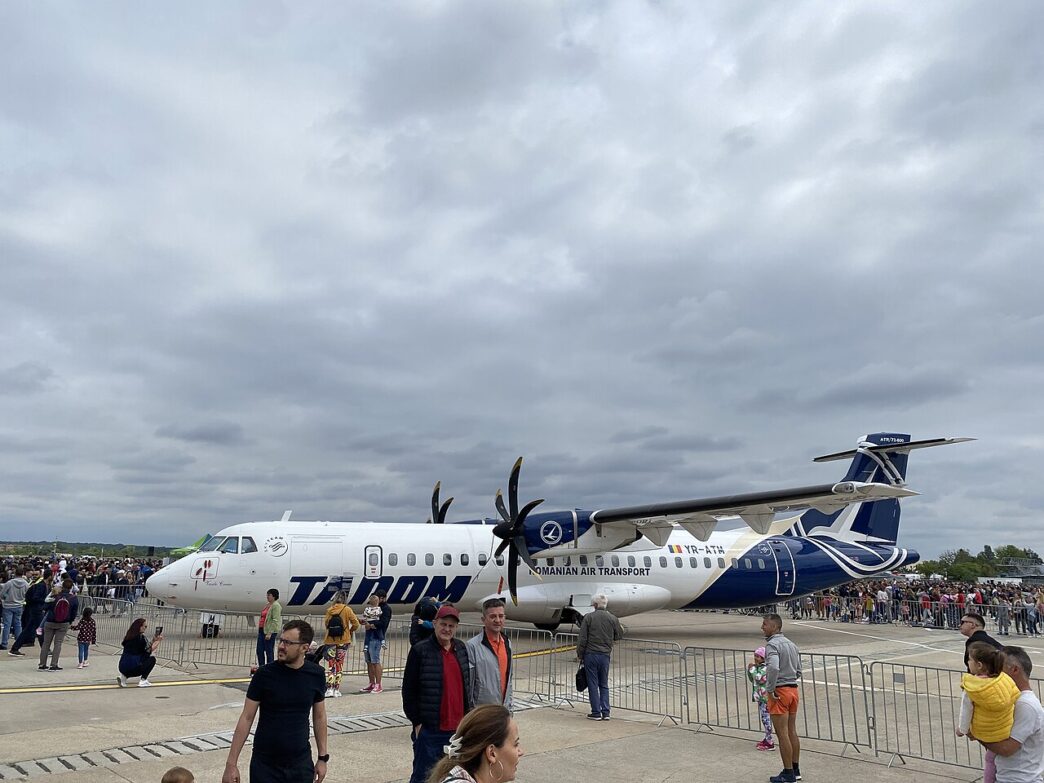 Avion ATR 72-600 în livrea TAROM, staționat pe platformă, cu vizitatori în prim-plan