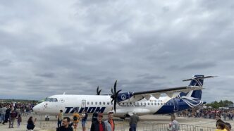 Avion ATR 72-600 în livrea TAROM, staționat pe platformă, cu vizitatori în prim-plan