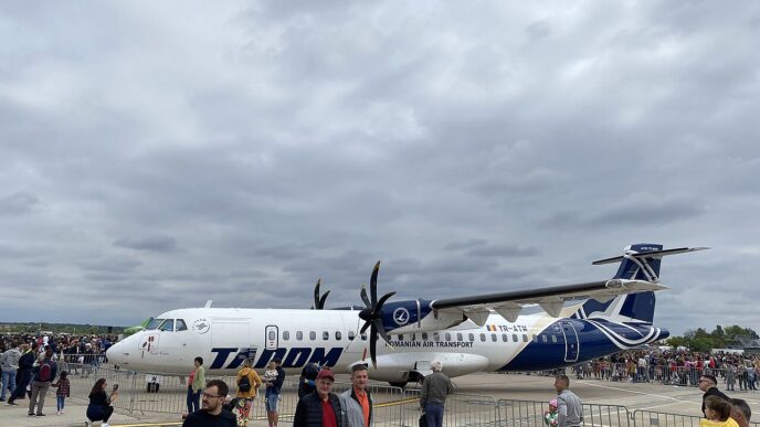 Avion ATR 72-600 în livrea TAROM, staționat pe platformă, cu vizitatori în prim-plan