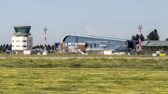 Terminalul de pasageri și turnul de control ale Aeroportului Internațional Suceava, văzute dinspre pistă