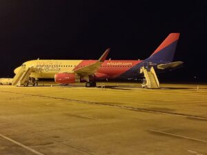 Avion Airbus A320 în culorile Wizz Air, parcat noaptea pe platforma Aeroportului Internațional Sibiu, cu scările de îmbarcare atașate